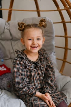 A small girl in a suspended bamboo chair