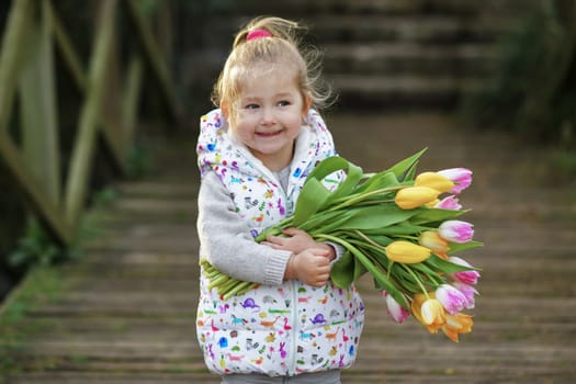 Portrait of a girl with a bouquet of tulips in her hands