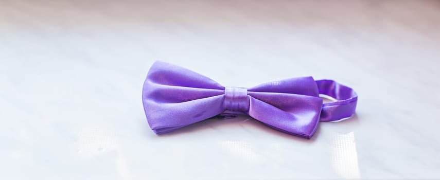 close-up of lilac ribbon bow tie on white background