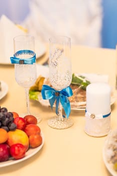 Close-up of wedding decorated champagne glasses on the table.