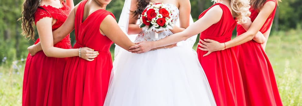 Bride with bridesmaids on the park on the wedding day.