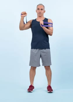 Full body length shot athletic and sporty senior man with fitness resistance band on isolated background. Healthy active physique and body care lifestyle after retirement. Clout