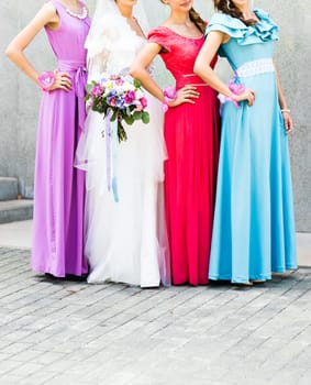 Bride with bridesmaids on the park on the wedding day.