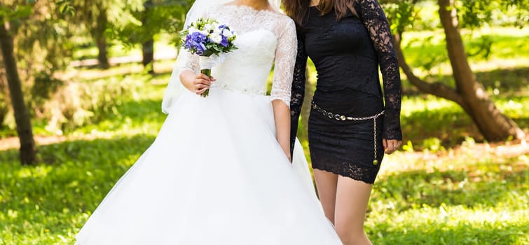 Bride with bridesmaids on the park on the wedding day.