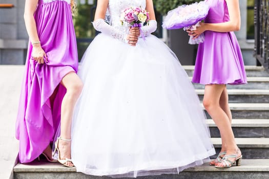 Bride with bridesmaids on the park on the wedding day.