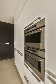 a kitchen with two ovens and an oven in the middle one is built into the wall, while the other has been installed