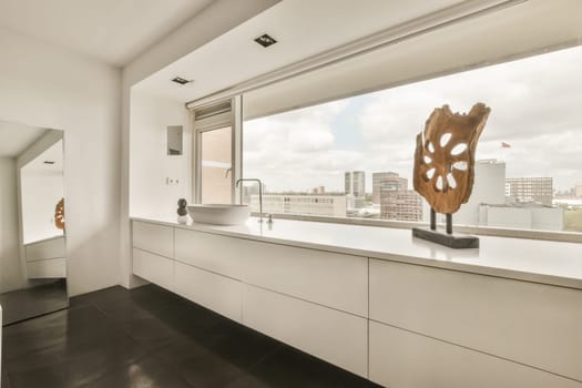 a modern bathroom with black tile flooring and white walls, along with a large window looking out onto the city skyline