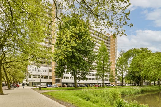 a river in the middle of a city with buildings on both sides and green trees lining the banks along it