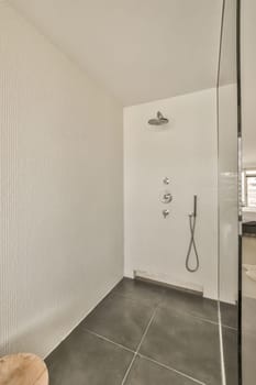 a bathroom with white tiles on the walls and black tile flooring around the bathtub, which is also used as a shower