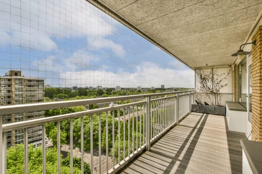 a balcony with trees and buildings in the background, as seen through a glass window panoray on a sunny day