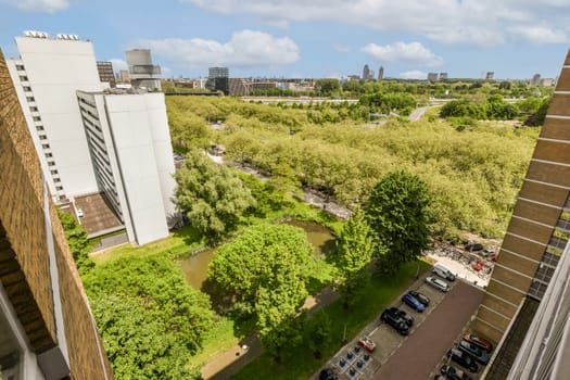 an urban area with buildings and trees in the fore, taken from a high angle on a clear blue sky day