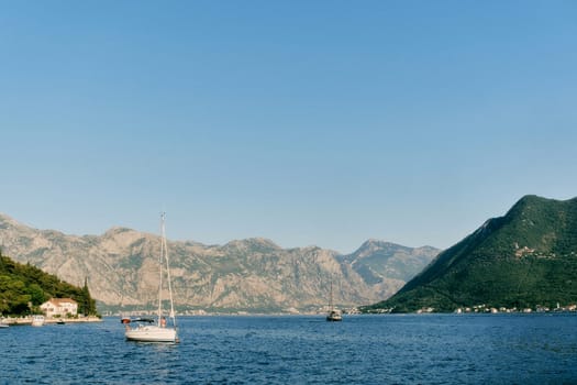 Small sailing yacht is moored in the sea near the coast of Perast. Montenegro. High quality photo