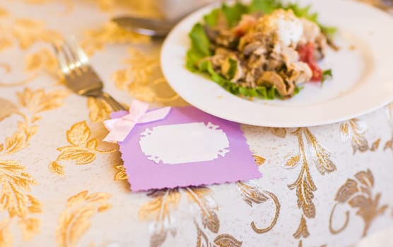 purple place card decorated with pink bow.