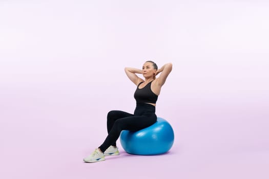 Full body length shot athletic and sporty senior woman with fitness exercising ball on isolated background. Healthy active and body care lifestyle after retirement. Clout