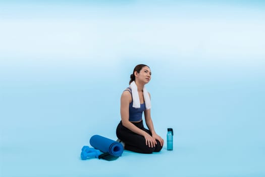 Athletic and sporty asian woman resting after intensive cardio workout training. Healthy exercising and fit body care lifestyle pursuit in studio shot isolated background. Vigorous