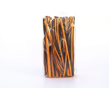 Black And Orange Pappardelle Italian Pasta In Package, Fresh Wheat Product on White Background. Egg Dry Ribbon Noodles, Long Rolled Macaroni or Uncooked Spaghetti Isolated. Horizontal Plane