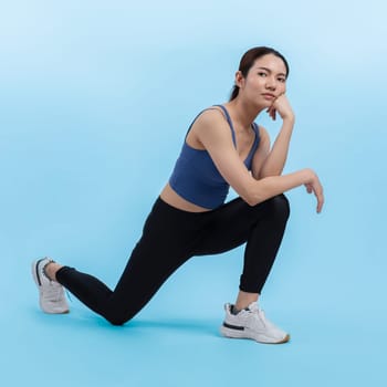 Young attractive asian woman in sportswear stretching before fitness exercise routine. Healthy body care workout with athletic woman warming up on studio shot isolated background. Vigorous