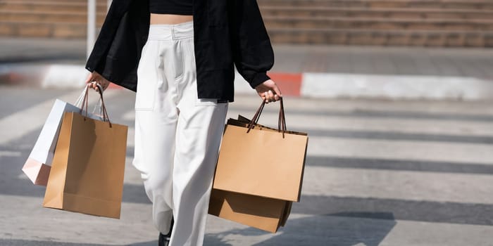 Young asian woman in shopping. Fashion woman in black with shopping bag walking around the city after shopping. Black friday.