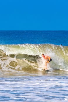 Puerto Escondido Oaxaca Mexico 13. November 2022 Surfer surfing on surfboard on high waves on beautiful sunny beach with blue sky in Zicatela Puerto Escondido Oaxaca Mexico.