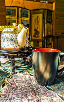 Red and black coffee cup on an elegant turquoise tablecloth in Para Heredia Costa Rica in Central America.