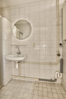 a bathroom with a sink, mirror and toilet roll on the wall next to it is a white tiled floor