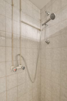 a shower that is in someone's bathroom with white tiles on the walls and tile around the shower head
