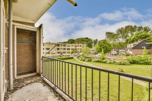 an outside area with some buildings in the background and green grass on the other side of the photo is clear blue sky