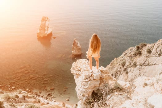 Woman travel sea. Happy tourist taking picture outdoors for memories. Woman traveler looks at the edge of the cliff on the sea bay of mountains, sharing travel adventure journey.