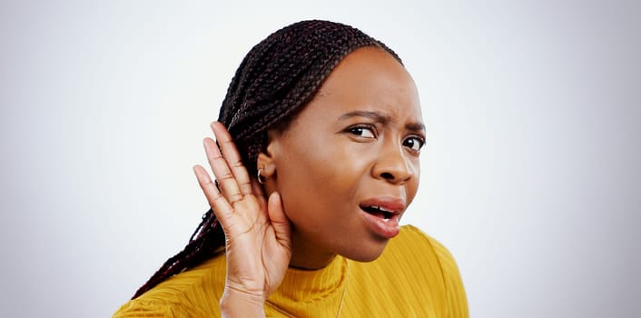 Portrait of black woman, hand and ear in studio for gossip, story or frustrated face by grey background. African girl, hearing or confused by secret information, news and communication with questions.