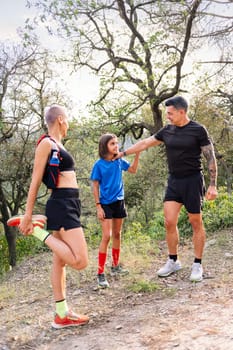 vertical photo of a family stretching and warming up for sports in the countryside, concept of sport with kids in nature and active lifestyle, copy space for text