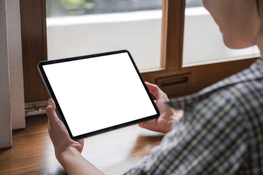 Mockup image of a woman holding digital tablet with blank white desktop screen.