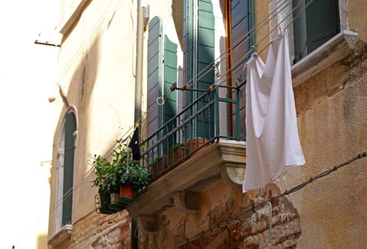 Gorgeous Venice. The narrow street channel. Picturesque laundry drying on clothesline