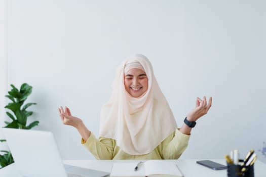 Muslim female employee Meditate while working in the office