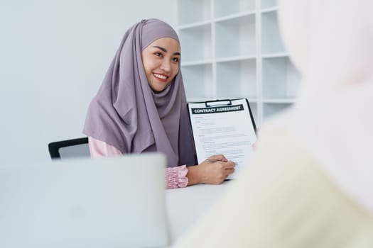Muslim female employee Hold important documents and discuss agreements with customers