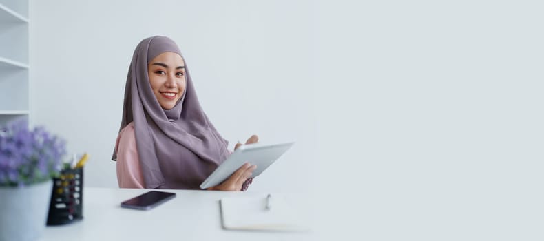 Muslim women use tablet computers, and laptops to check their accounts at work