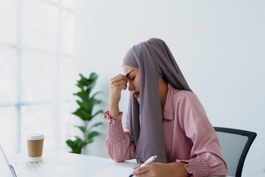 Muslim female employee working in office burnout