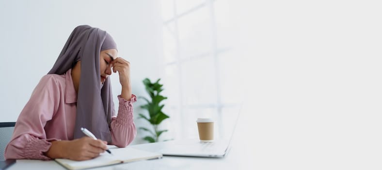 Muslim female employee working in office burnout