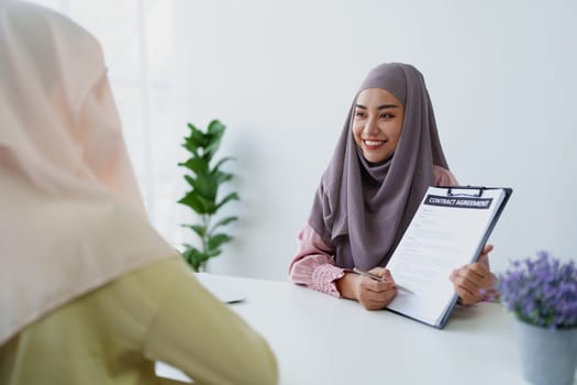 Muslim female employee Hold important documents and discuss agreements with customers