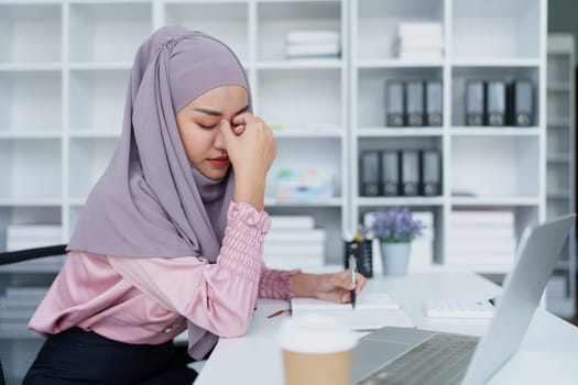 Muslim female employee working in office burnout