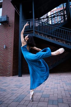 Beautiful Asian ballerina dancing outdoors. Urban landscape