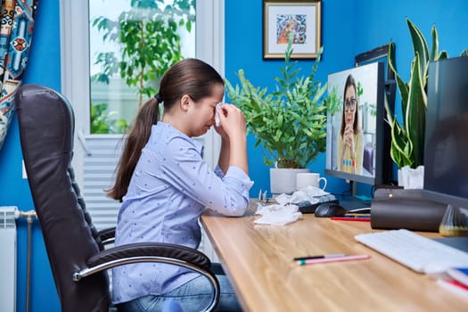 Teenage upset crying girl on online therapy with a psychologist. Sad female sitting at home talking on video conference chat with counselor therapist. Adolescence, psychology, psychotherapy, therapy