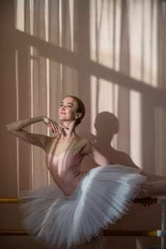 Portrait of a graceful ballerina in a white tutu in a dance class