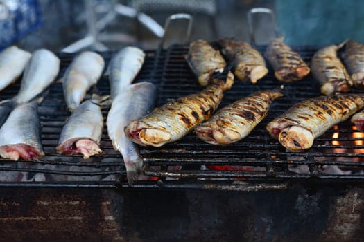 fried herring on the grill on the street market