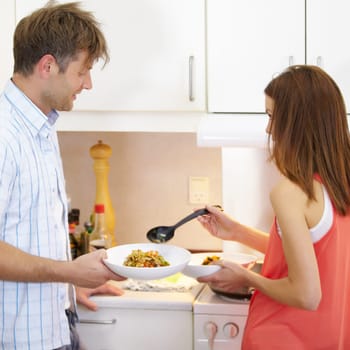 Couple, dish and stir fry in home kitchen in at stove for nutrition, health or plate with help. Chef woman, cooking and man with vegetables for diet, wellness and vegan lunch with thinking in house.
