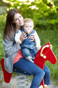 Portrait, mother and baby with toy, horse and park for fun in bond by playing for outside together. Happy woman, infant or smile for milestone, future growth or development with love, support or care.