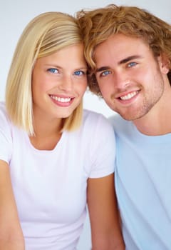 Portrait, love and smile with a young couple together in their home on the weekend for romance or to relax. Face, happy or dating with a man and woman bonding in their apartment for wellness.