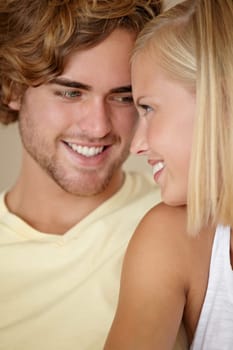 Face, love and smile with a young couple closeup in their home together for romance or bonding. Relax, happy or dating with a man and woman in their apartment to relax during a weekend break.