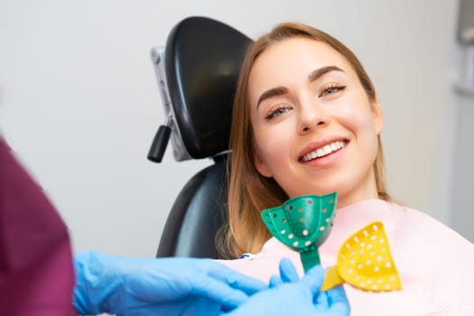 A dentist carefully chooses plastic molds for taking impressions to create alignments