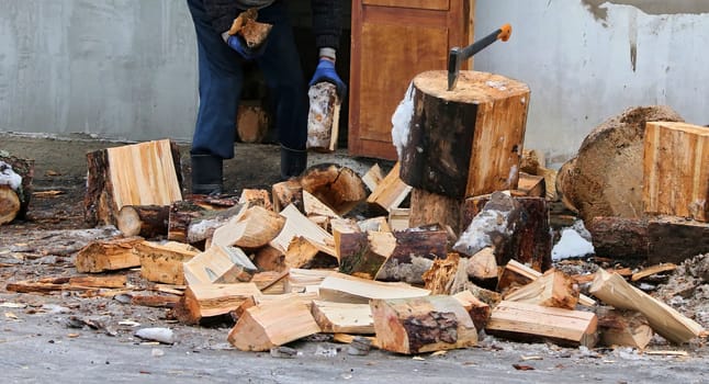 Old ax and a deck for chopping wood. Dry firewood, chopped wood for winter heating of the fireplace.