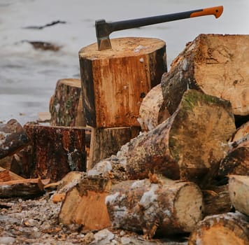 Old ax and a deck for chopping wood. Dry firewood, chopped wood for winter heating of the fireplace.